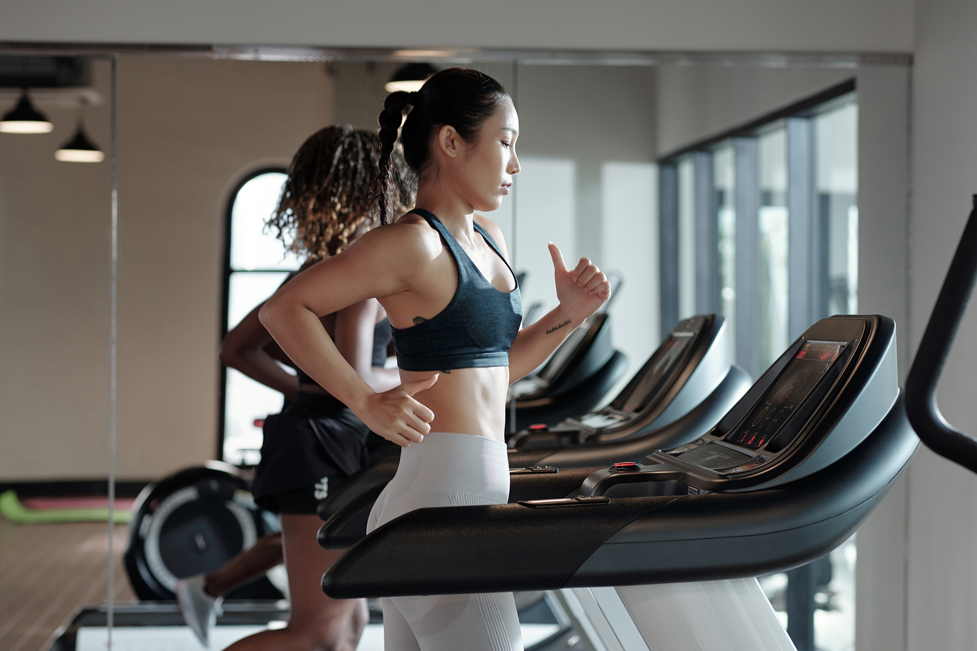 Young Woman with black hair Jogging on Treadmill